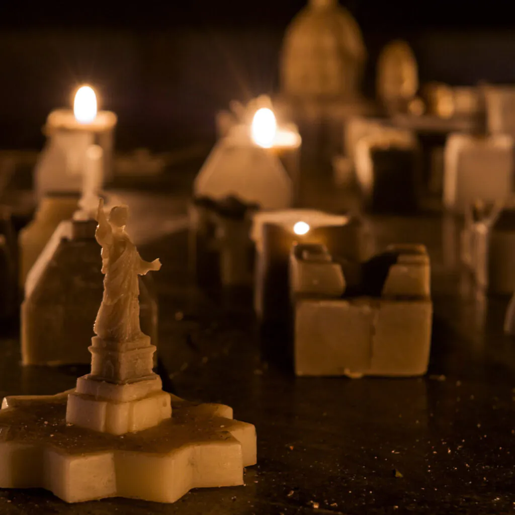 Carlos Garaicoa, Ahora Juguemos a Desaparecer (II), 2002, [detalhe],  mesa de metal, velas, instalação de vídeo, dimensões variáveis. Foto: William Gomes